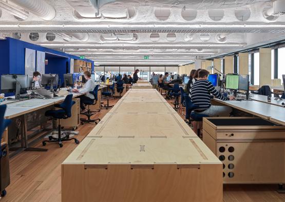 a large wooden desk with people sitting at it