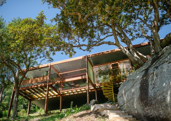 a building with a large rock and trees