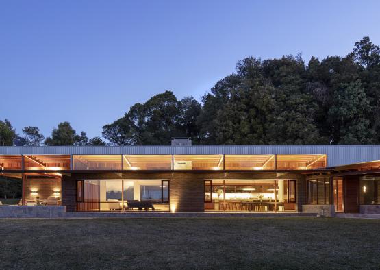 a building with a large glass wall and a large lawn