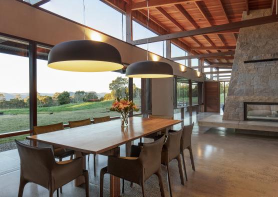 a dining table with chairs and a large stone fireplace