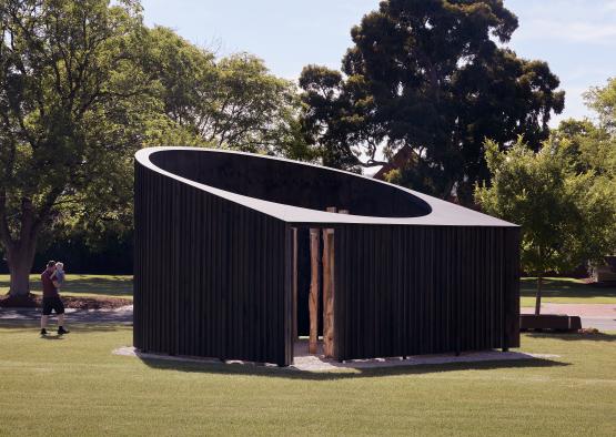 a wooden structure in a grassy area