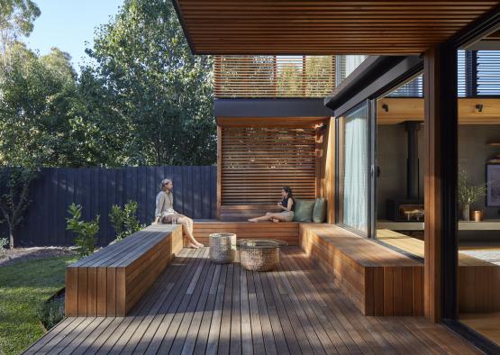 a couple of women sitting on a deck