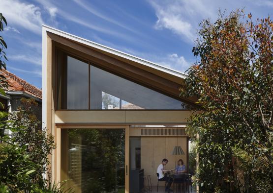 a house with a triangular roof and glass walls