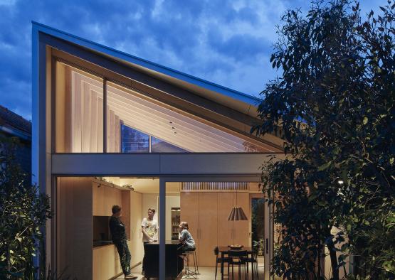 a house with a glass wall and a tree