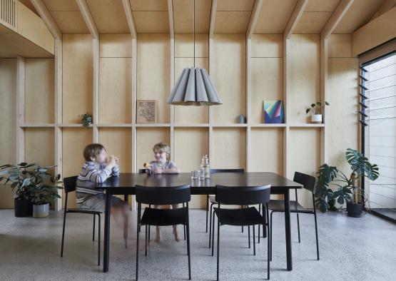 two kids sitting at a table in a room