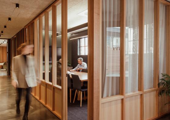 a person walking through a room with a wood wall