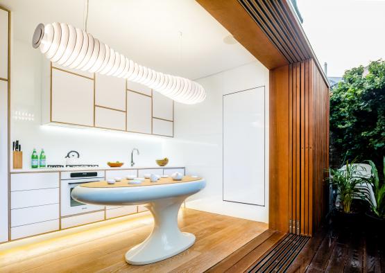 a white kitchen with a large oval table