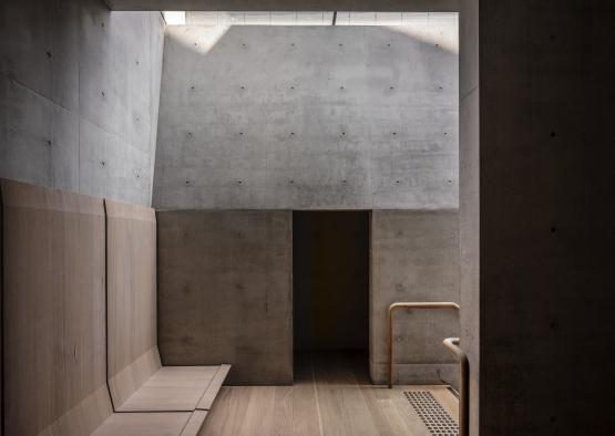 a concrete room with a bench and a door
