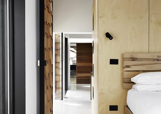 a bedroom with a wood paneled wall and a bed