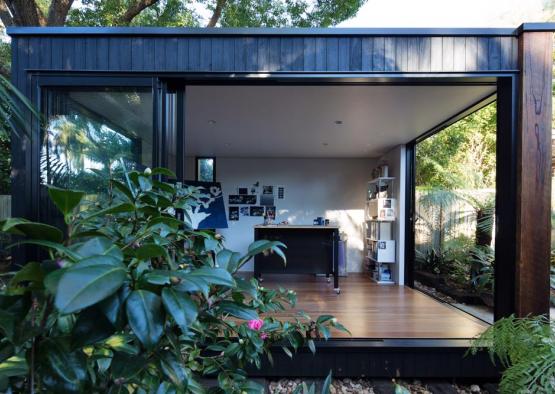 a glass room with a desk and a wood floor