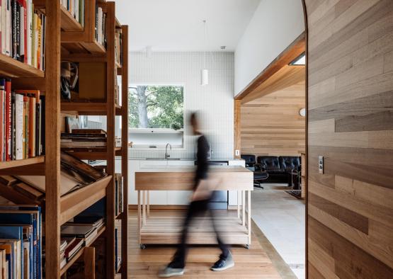 a person walking in a room with bookshelves
