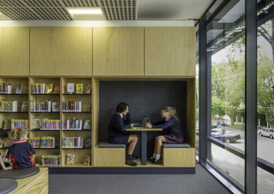 a couple of people sitting at a table in a library