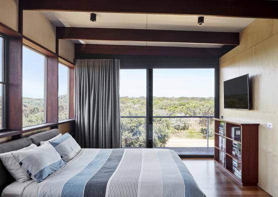 a bedroom with a large window and a large bed