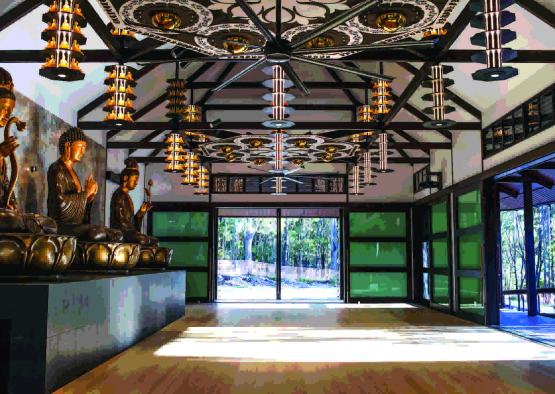 a room with a large ceiling fan and a statue of a buddha