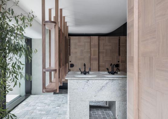 a bathroom with a sink and wood partitions