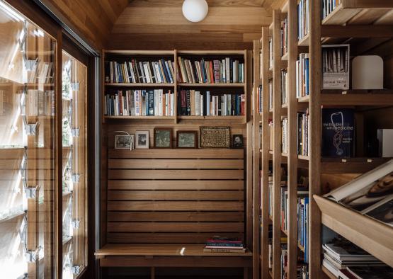 a room with a wood wall and shelves with books
