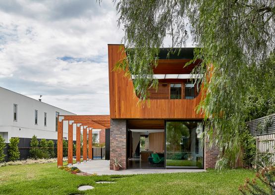 a house with a green lawn and a tree