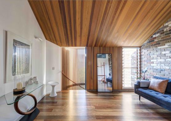 a room with a wood ceiling and a mirror