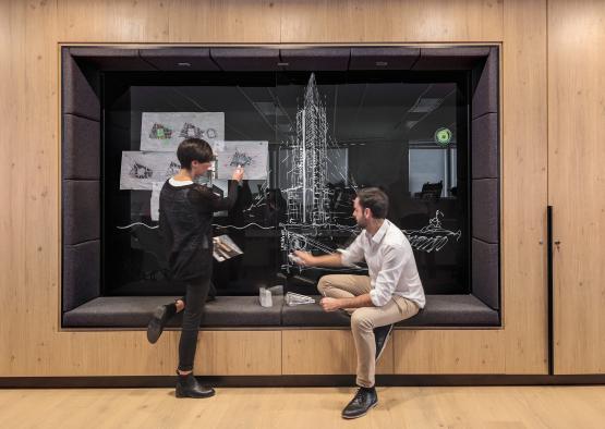 a man and woman drawing on a glass window