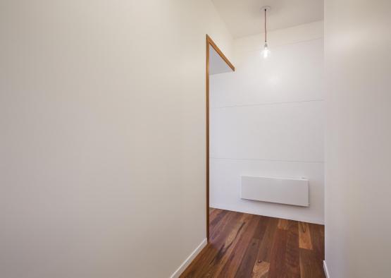 a hallway with a wood floor and a light bulb