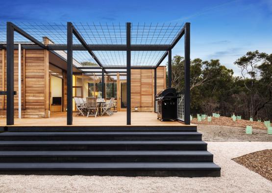 a patio with a grill and a wooden structure