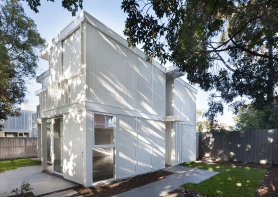 a white house with a fence and grass