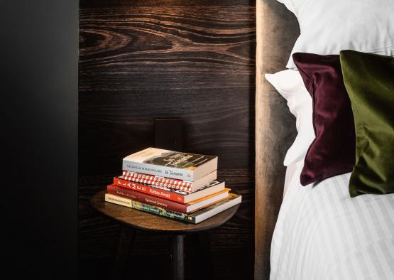 a table with books on it next to a bed