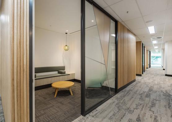 a hallway with glass walls and a table