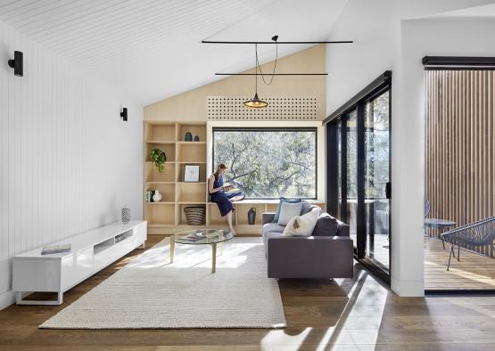 a woman in a room with a couch and a window