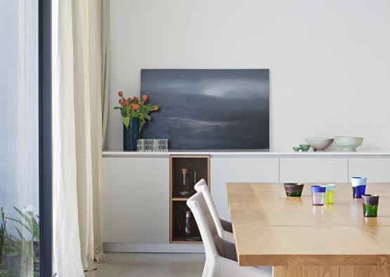 a dining table with a painting on the wall