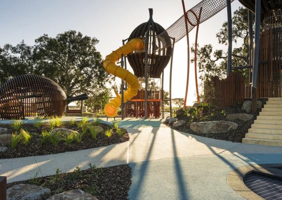 a playground with a slide and a ball and a bridge