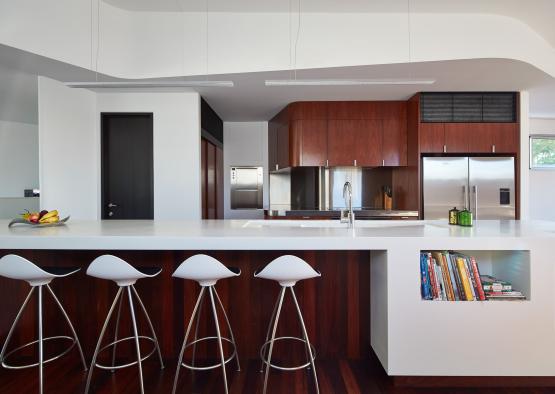 a kitchen with white countertops and stools