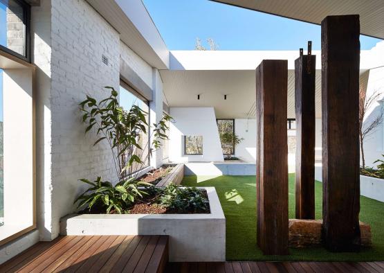 a patio with a wooden bench and plants