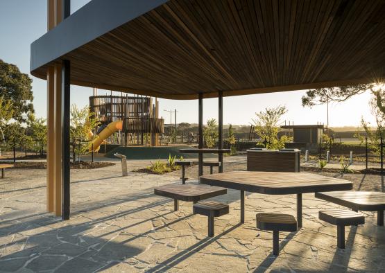 a group of tables and benches under a structure