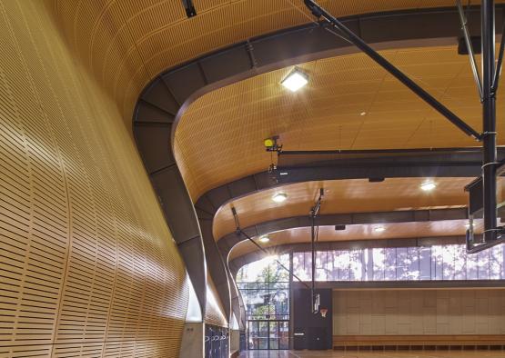a gym with a wooden floor and a basketball court
