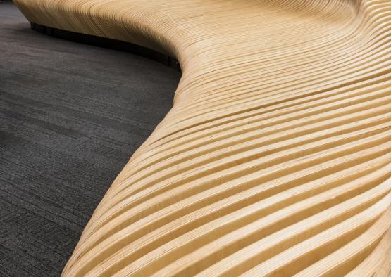 a wooden curved bench in a room