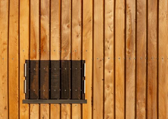 a wooden wall with a square window