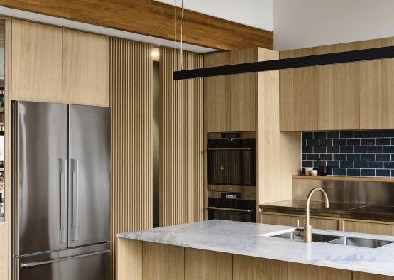 a kitchen with a stainless steel refrigerator and bar stools