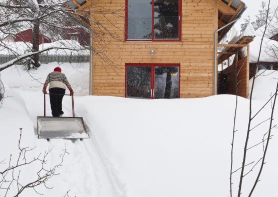 a person shoveling snow outside a house