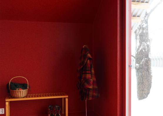 a red room with a bench and shoes