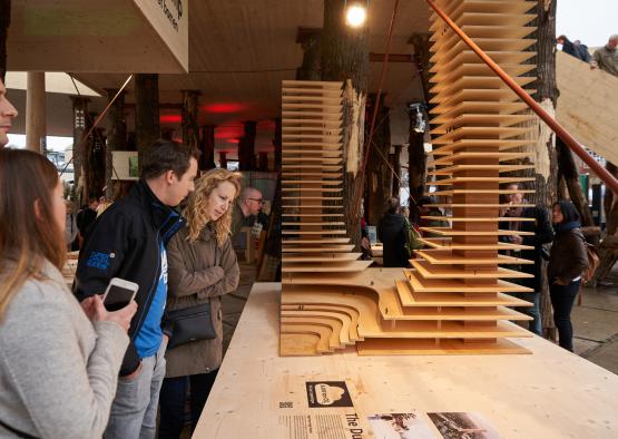 people standing around a table with a sculpture of a structure