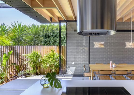 a kitchen with a hood over a table and chairs