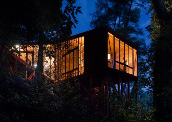 a house on a hill with trees in the background