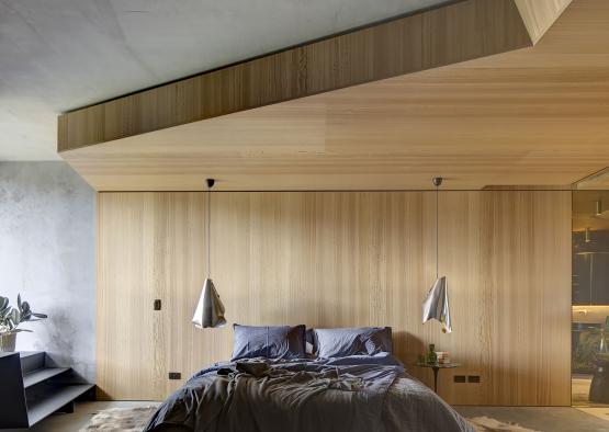 a bedroom with a bed and a wood wall