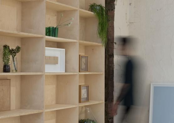 a person walking in a room with shelves