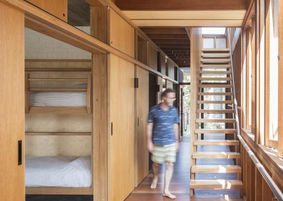 a man walking in a room with bunk beds