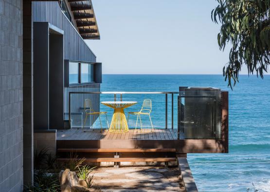 a deck with a table and chairs overlooking the ocean