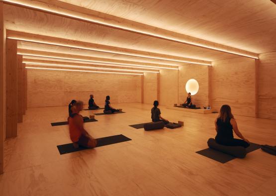 a group of people sitting on mats in a room with a light