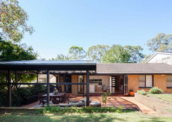 a house with a covered patio and a person sitting on a bench