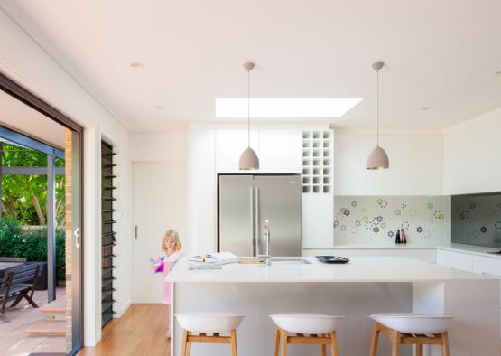 a kitchen with a white island and stools